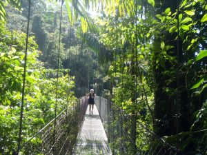 Kvinde på hængebro i regnskoven i Costa Rica